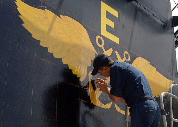 (May 3, 2007) - Aviation Boatswain?s Mate (Handling) Airman Thomas Vincent outlines the outside of the golden anchors aboard USS