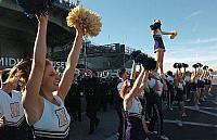San Diego (Dec. 21, 2005) - U.S. Naval Academy cheerleaders show their team's spirit in front of the decommissioned aircraft car